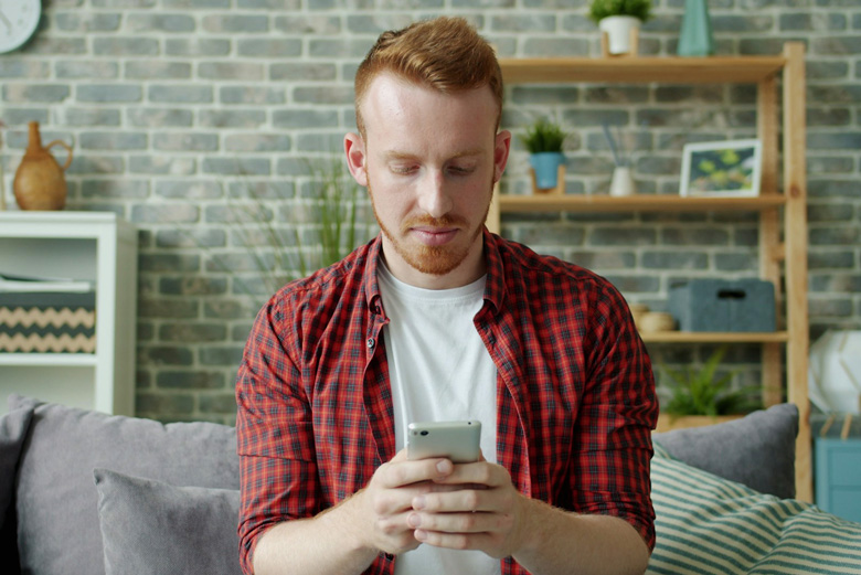 Ragazzo che tiene e usa il telefono per chattare su WhatsApp